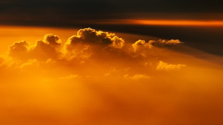 Captivating view of golden clouds illuminated by the warm glow of sunset, creating a serene and epic atmosphere.