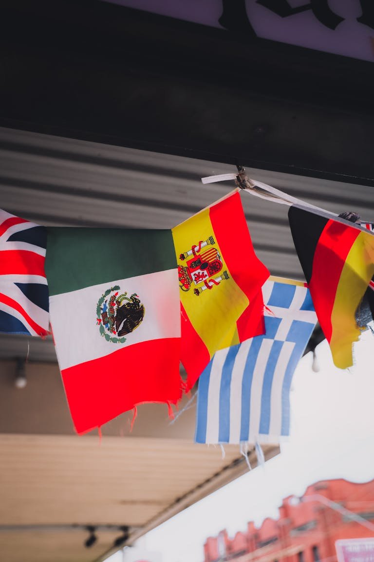 A vertical shot showcasing multiple national flags hanging outdoors, symbolizing global unity.